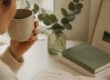 Learn from this woman in planning your day in a notebook with a cup of coffee.